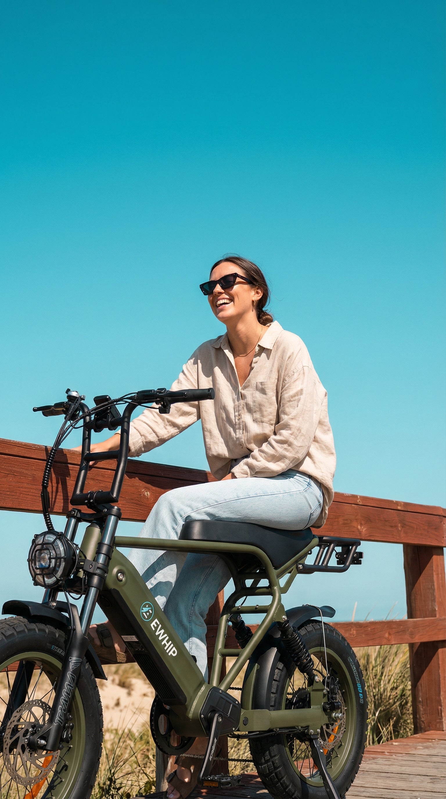 Stylish street-legal e-bike with Samsung battery, EN15194 certified, ridden by smiling woman on wooden deck